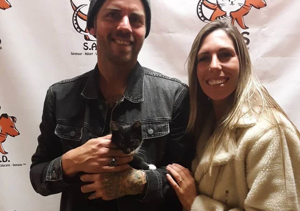 couples smiles for new adopted cat